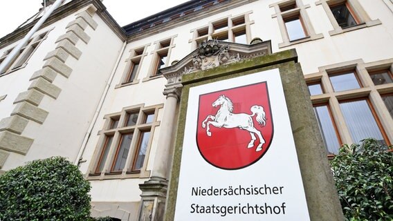 Auf einem weißen Schild steht unter dem Wappens Niedersachsens "Niedersächsischer Staatsgerichtshof". © picture alliance/dpa | Holger Hollemann Foto: Holger Hollemann