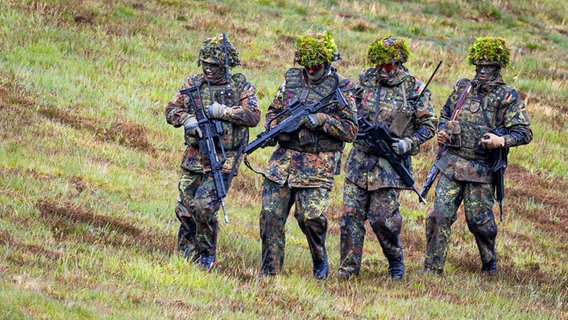 Reservisten nehmen mit G36-Gewehren beim Besuchertag "Heimatschutz" auf dem Gelände der Clausewitz-Kaserne in Nienburg/Weser an einer Vorführung (Gefechtsschießen) teil. © picture alliance/dpa | Moritz Frankenberg Foto: Moritz Frankenberg