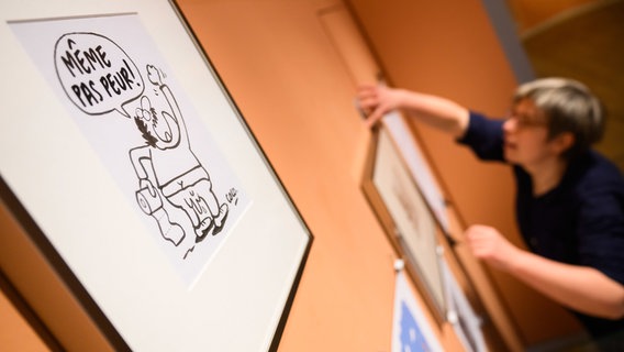 Das Bild "Meme pas peur!" (dt. "Ich habe keine Angst") der französischen Karikaturistin Coco hängt in der Ausstellung "Die Freiheit der Kunst" im Museum Wilhelm Busch in Hannover. © dpa-Bildfunk Foto: Julain Stratenschulte