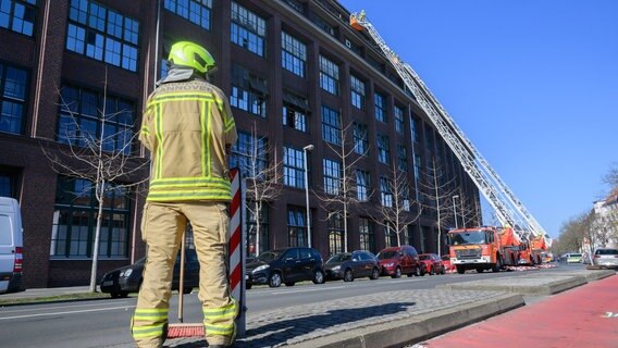 Feuerwehrleute sichern von Drehleitern aus eine bei einer Explosion beschädigte Fassade an einem Gebäude von Continental in Hannover. © Julian Stratenschulte / dpa / dpa-Bildfunk Foto: Julian Stratenschulte