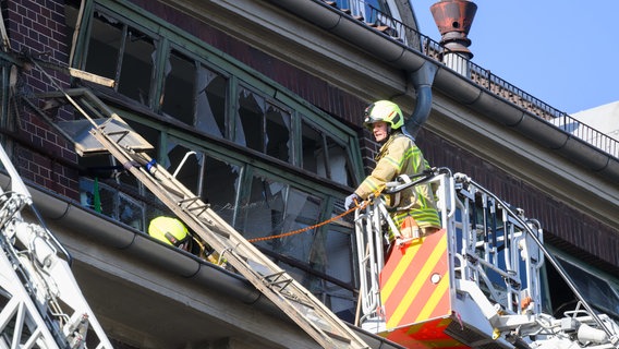 Feuerwehrleute sichern von Drehleitern aus eine bei einer Explosion beschädigte Fassade an einem Gebäude von Continental in Hannover. © Julian Stratenschulte / dpa / dpa-Bildfunk Foto: Julian Stratenschulte