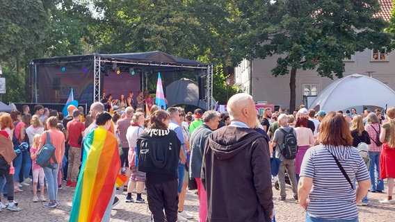 Menschen stehen beim CSD Burgdorf vor einer Bühne. © NDR Foto: Roy Gündel