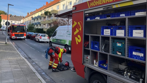 Einsatzfahrzeuge der Feuerwehr und eine Rettungskraft vor dem Mehrfamilienhaus in Hannover © Feuerwehr Haannover 