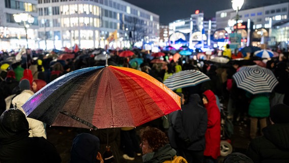 Zahlreiche Menschen nehmen mit bunten Regenschirmen an einer Demonstration zur Migrationspolitik auf dem Opernplatz in der Innenstadt teil. © dpa Bildfunk Foto: Michael Matthey