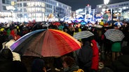 Zahlreiche Menschen nehmen mit bunten Regenschirmen an einer Demonstration zur Migrationspolitik auf dem Opernplatz in der Innenstadt teil. © dpa Bildfunk Foto: Michael Matthey