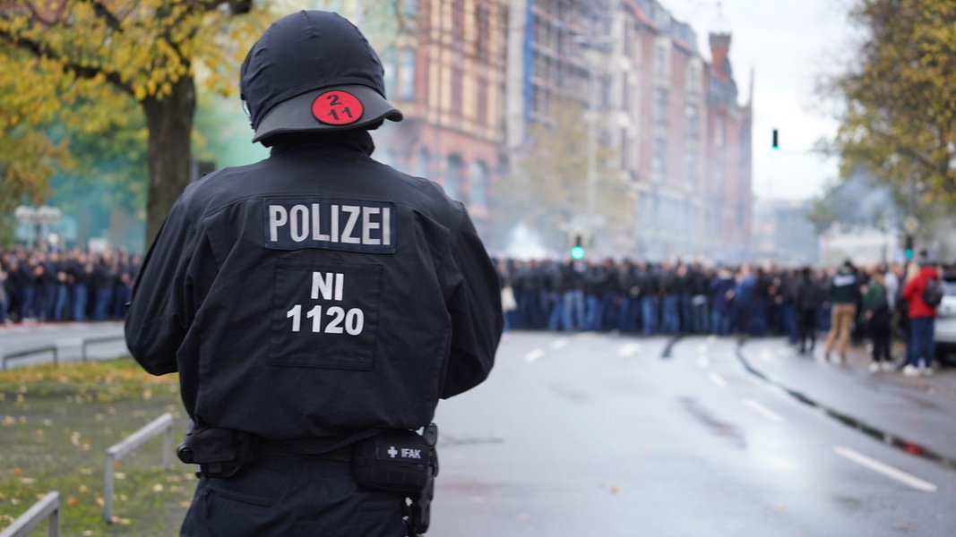 Fußballfans auf dem Weg zum Stadion von Hannover 96 werden von der Polizei begleitet.