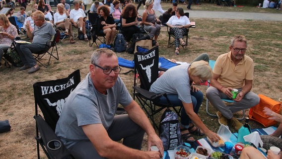 Besucher sitzen beim NDR Klassik Open Air 2018 (Generalprobe) im Maschpark auf "Wacken"-Klappstühlen. © NDR Foto: Julia Scheper