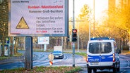 Eine Infotafel an einer Straße informiert über eine Evakuierung wegen einer Bombensondierung. Daneben steht ein Polizeifahrzeug. © dpa Bildfunk Foto: Moritz Frankenberg