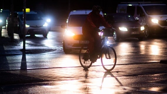 Ein Fahrradfahrer überquert im Dunkeln eine Kreuzung. © dpa-Bildfunk Foto: Julian Stratenschulte