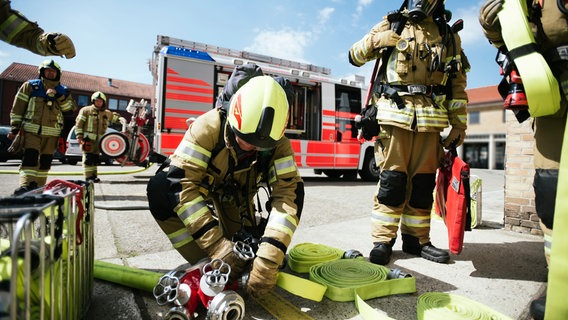 Ein Feuerwehrmann schließt bei einer Übung in Hannover Wasserschläuche an. (Archivbild) © NDR Foto: Julius Matuschik