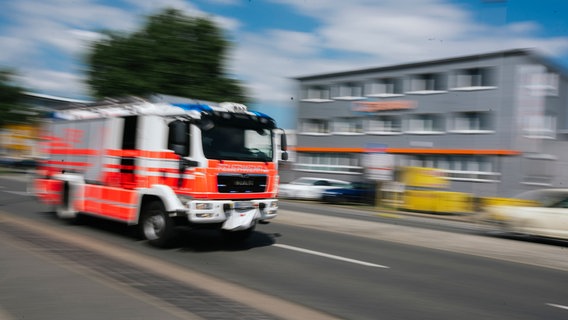 Ein Feuerwehrfahrzeug in Unschärfe bei einer Einsatzfahrt in Hannover. © NDR Foto: Julius Matuschik