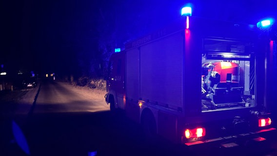 Ein Feuerwehrauto steht bei Dunkelheit am Straßenrand. © FW Flotwedel Foto: FW Flotwedel