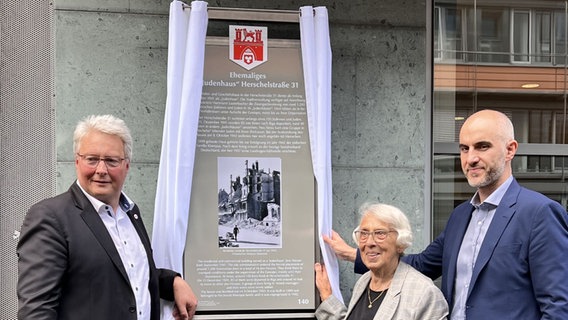 Drei Menschen stehen vor einer enthüllten Tafel an einer Hausfassade. © SOvD Niedersachsen 