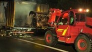 Ein Radlader holt Fässer aus einem ausgebrannten Lastwagen. © HannoverReporter 