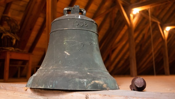 Die abgehängte Glocke aus der NS-Zeit, die mit einem Hakenkreuz versehen ist, steht auf dem Boden der Michaelkirche. © picture alliance/dpa Foto: Philipp Schulze