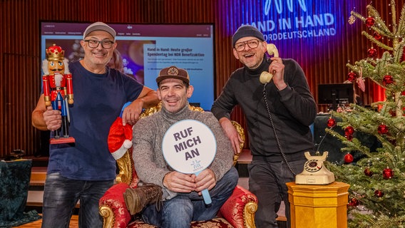 Drei Männer sitzen bei der Spendenaktion "Hand in Hand" auf einer Couch. © NDR Foto: Axel Herzig