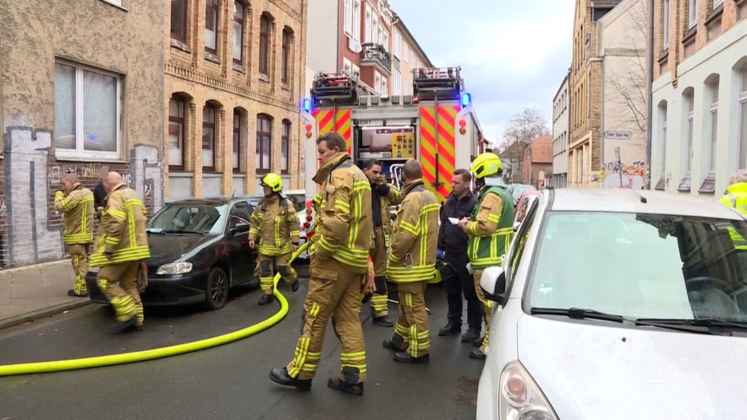 Einsatzkräfte der Feuerwehr stehen vor einem Wohnhaus in Hannover in dem eine Person bei einem Bran ums Leben gekommen ist. 
