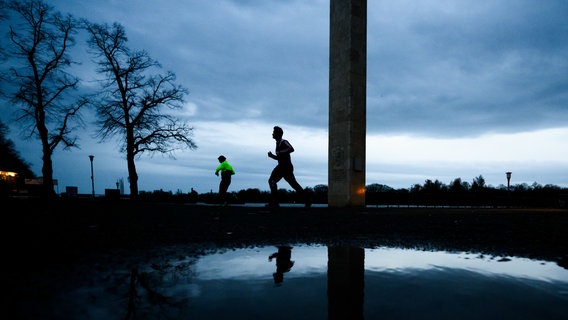 Jogger laufen am frühen Morgen bei trüben Wetter am Nordufer vom Maschsee. © dpa-Bildfunk Foto: Julian Stratenschulte