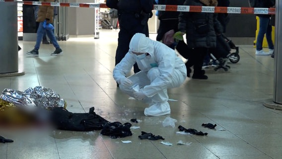 Beamte der Kriminalpolizei untersuchen im Bahnhof einen abgesperrten Bereich, in dem ein 47-Jähriger mit Stichverletzungen lebensgefährlich verletzt wurde. © TeleNewsNetwork 