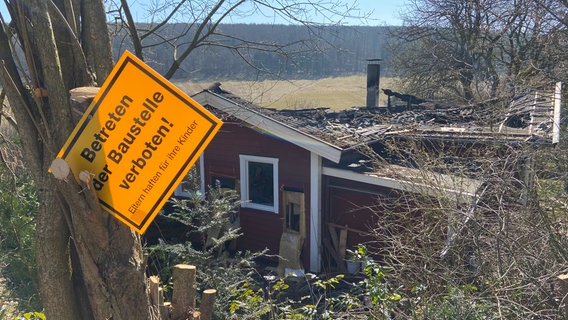 Ein "Baustelle, Betreten verboten" Schild hängt vor einem Haus, dass bei einem Brand in Hellenthal zerstört wurde. © NDR Foto: Wolfgang Kurz