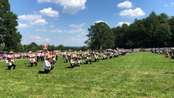 Menschen in Kostümen spielen eine Kriegsschlacht auf einem Feld. © NDR Foto: Wilhelm Purk