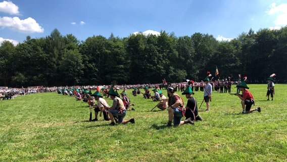 Menschen in Kostümen spielen eine Kriegsschlacht auf einem Feld. © NDR Foto: Wilhelm Purk