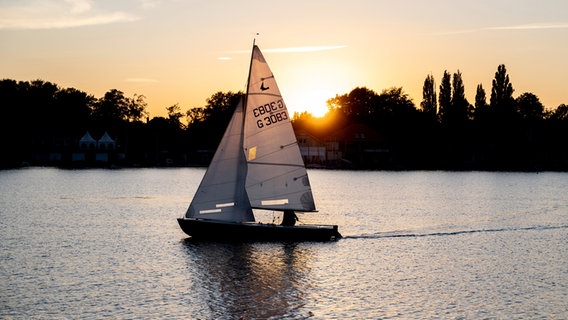 Ein Segler ist vor der untergehenden Sonne auf dem Maschsee unterwegs. © dpa-Bildfunk Foto: Hauke-Christian Dittrich