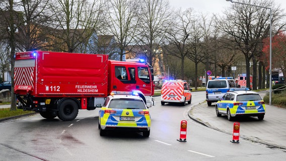 Einsatzkräfte von Feuerwehr und Polizei sperren eine Straße in Hildesheim ab. © Julian Stratenschulte/dpa Foto: Julian Stratenschulte