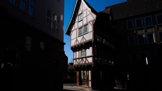 Das Hildesheimer Fachwerkhaus, das auch "umgestülpter Zuckerhut" genannt wird, wird von der Sonne angestrahlt. © dpa Foto: Julian Stratenschulte