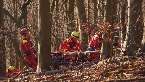 Bei einer Höhenrettung an einem Hang sind mehrere Menschen mit Seilen und Trage im Einsatz. © HannoverReporter 