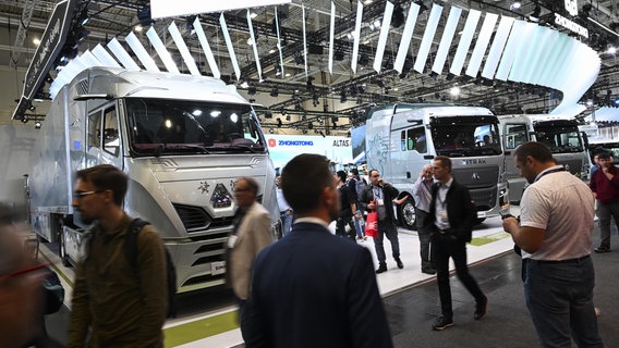 Besucher laufen auf der IAA Transportation Messe in Hannover an mehreren Lkw vorbei. © picture alliance / Anadolu Foto: Halil Sagirkaya