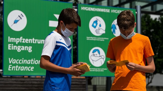 Zwei Jugendliche schauen in ihre Impfpässe. © NDR Foto: Moritz Frankenberg