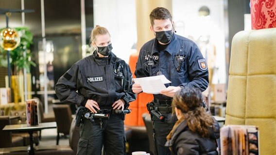 Beamte der Bereitschaftspolizei kontrollieren in Hannover die Impfnachweise von Restaurantgästen während einer Corona-Kontrolle. © dpa Foto: Ole Spata