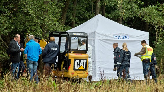 Polizisten stehen am 2. September 2014 an einem Waldrand in Blumenau in der Region Hannover, wo sie menschliche Knochen entdeckt haben. © picture alliance / dpa Foto: Julian Stratenschulte