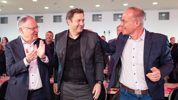 Lars Klingbeil  wird von Stephan Weil  und Matthias Miersch auf dem Parteitag der SPD Niedersachsen beglückwünscht. © dpa-Bildfunk Foto: Moritz Frankenberg