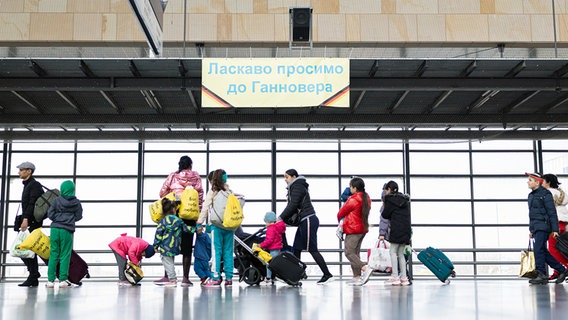Geflüchtete aus der Ukraine gehen durch die Eingangshalle vom Messebahnhof Laatzen. © dpa bildfunk Foto: Michael Matthey