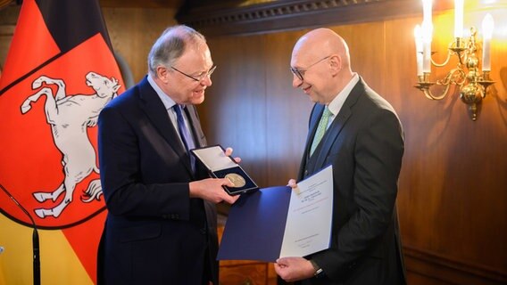 Stephan Weil (l, SPD) verleiht im Gästehaus der Landesregierung die Niedersächsische Landesmedaille, die höchste Auszeichnung des Landes Niedersachsen, an den Wissenschaftler Stefan Hell. © dpa Foto: Julian Stratenschulte