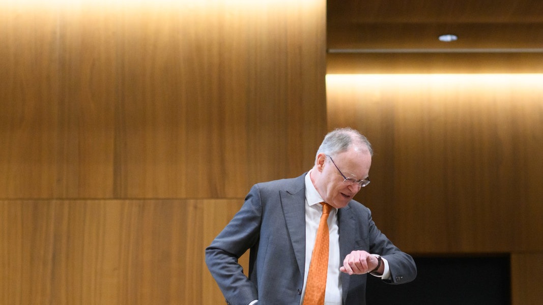Stephan Weil (SPD), Ministerpräsident Niedersachsen, steht im niedersächsischen Landtag und schaut auf eine seine Uhr. 
