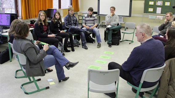 Lehramtsstudenten sitzen gemeinsam mit Lehrern in einem Klassenraum. © NDR Foto: Jens Otto