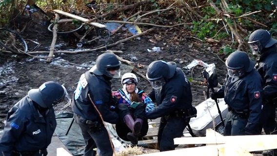Einsatzkräfte der Polizei tragen eine Frau aus dem Protestcamp in der Leinemasch. © NEWS5 