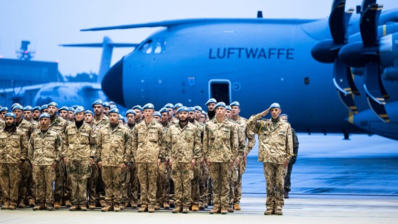 Soldaten stehen bei einem Rückkehrerappell in einem Hangar auf dem Gelände vom Fliegerhorst Wunstorf. © dpa-Bildfunk / dpa Foto: Michael Matthey