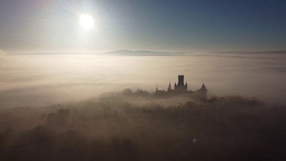 Schloss Marienburg liegt im Gegenlicht im Nebel. © Fernando Martinez/dpa Foto: Fernando Martinez/dpa