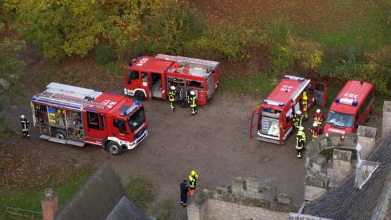 Einsatzfahrzeuge der Feuerwehr stehen vor der Marienburg bei Pattensen. © NDR 