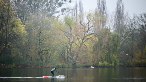 Ein Stand-Up-Paddler gleitet am frühen Morgen bei trüben Herbstwetter über den Maschsee. © dpa-Bildfunk 