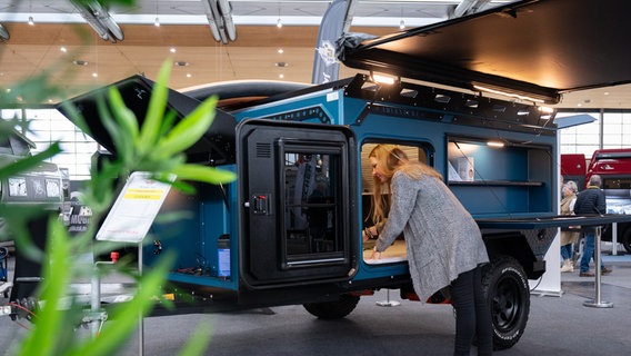 Eine Frau schaut sich einen Wohnwagen auf der ABF Messe 2024 an. © Deutsche Messe Foto: Rainer Jensen