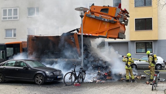 Feuerwehrleute löschen das Feuer in einem brennenden Müllauto in Hannover. © dpa-Bildfunk Foto: Kilian Genius