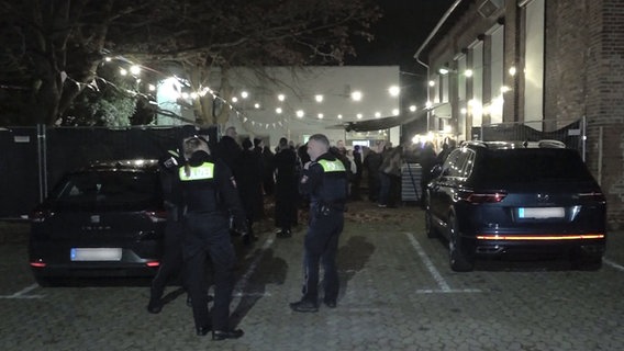 Besucher eines Konzertes und Polizisten stehen vor der evakuierten Konzerthalle "MusikZentrum" in Hannover. © TNN/dpa 