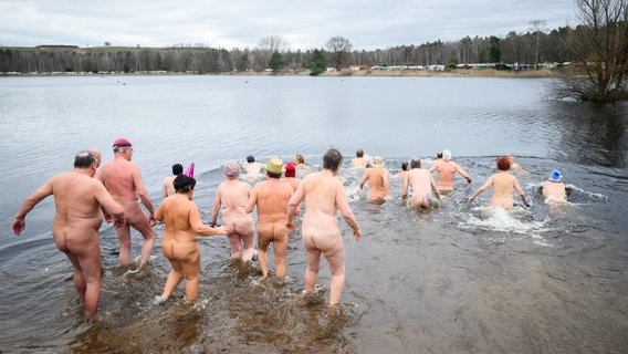 Nackte Schwimmer laufen beim Neujahrs-Nackt-Schwimmen in den Sonnensee. © dpa-Bildfunk Foto: Julian Stratenschulte