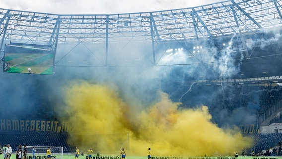 Fußballfans zünden gelben Rauch einem Stadion ab. © picture alliance/dpa Foto: Axel Heimken