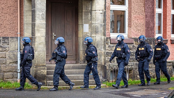 Polizeikräfte gehen vor einer Schule in Peine entlang. © dpa Foto: Moritz Frankenberg